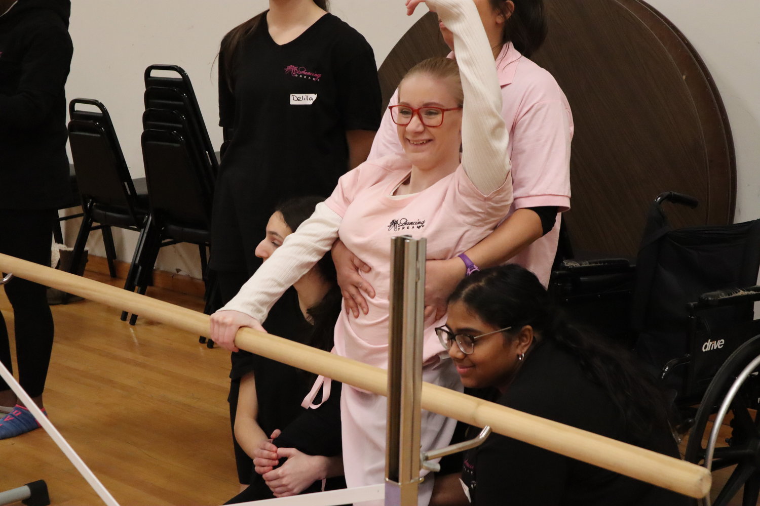 Abigail Penny, a young Merokean with spina bifida, expresses her movements through her arms while holding the barre.